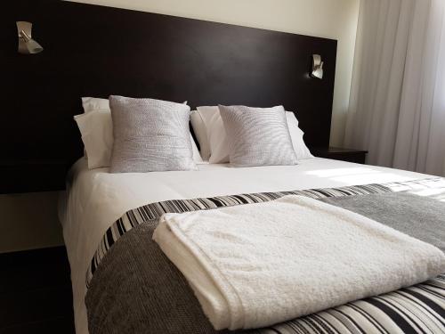 安托法加斯塔Tempora Apart Hotel的一间卧室配有带白色床单和枕头的床。