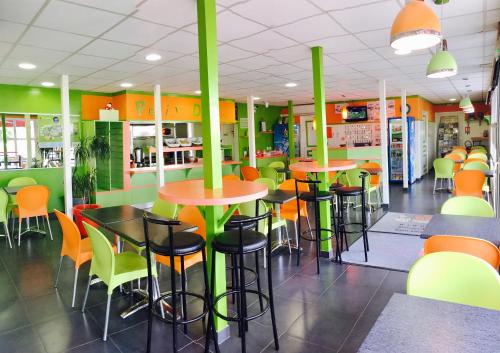 若奈克朗普瓦捷未来世界法斯特酒店的一间设有绿色和橙色桌椅的餐厅