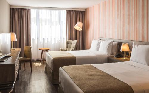 里韦拉Frontier Hotel Rivera的酒店客房配有两张床和一张书桌