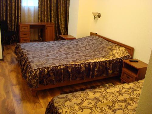 第聂伯罗Отель Гармония的一间卧室配有一张床、梳妆台和桌子