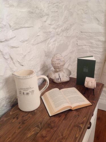 穆尔兰尼Mulranny House的茶杯和木桌上的一本开放式书