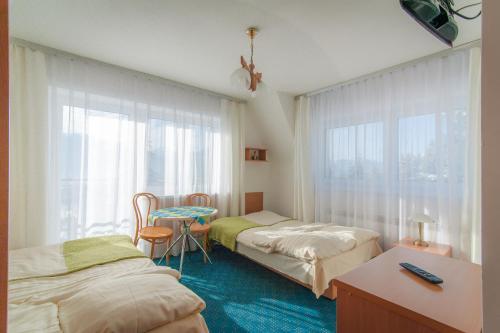 考斯赛力克Nasz Dom的客房设有两张床、一张桌子和一扇窗户。