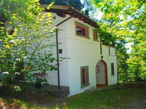 圣马尔切洛皮斯托耶塞Belvilla by OYO La Loggia的一间白色的小房子,有红窗和树木