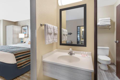 斯波坎谷SilverStone Inn & Suites Spokane Valley的一间带水槽、床和镜子的浴室
