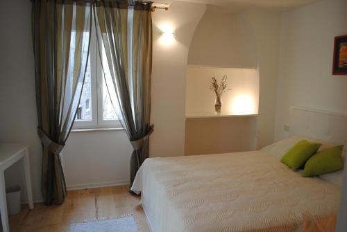 茨雷斯皮亚泽塔客房旅馆的一间卧室配有一张带绿色枕头的床和一扇窗户