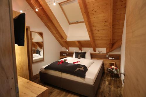 伊施格尔Apart Salner的一间带一张床的卧室,位于带木制天花板的房间内