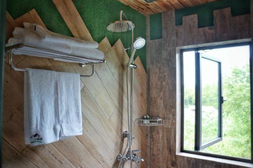 德清莫干山外安5号精品民宿的带淋浴和毛巾的浴室以及窗户。