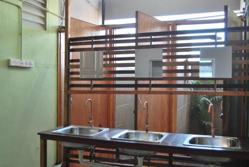 古晋Borneo Sweet Guesthouse的公共厕所里一排三个水槽