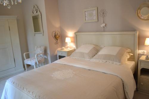 普洛布塞姆库尔安格莱斯度假屋的卧室配有白色的床和椅子