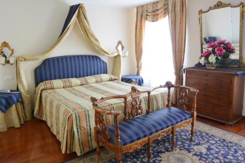威尼斯圣祖立安酒店的一间卧室配有一张床、梳妆台和镜子