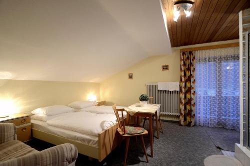 尼德恩西尔Ferienwohnung Nussbaumer的酒店客房带一张床、一张桌子和椅子