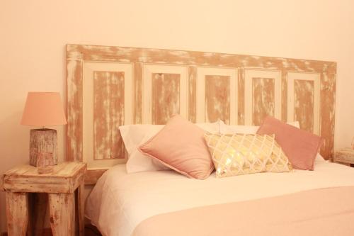 辛特拉拉努伊旅舍的一间卧室配有一张带木制床头板和枕头的床。