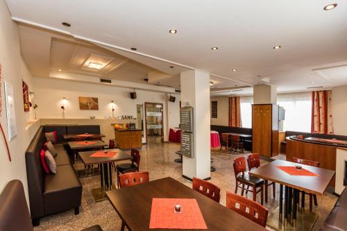 福尔希多夫Hotel Denk Bed & Breakfast的一间带桌椅的餐厅和一间酒吧