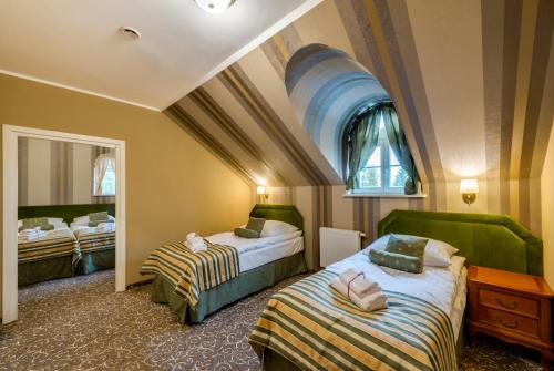 戈卢布-多布任Hotel Dwór Fijewo的酒店客房设有两张床和窗户。