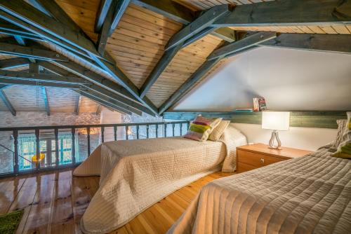 Pandokrátor圣安东尼奥别墅的配有木天花板的客房内的两张床
