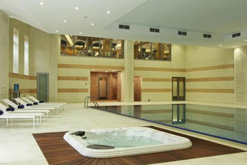 比什凯克比什凯克猎户座酒店的一座大楼中央的带热水浴池的游泳池