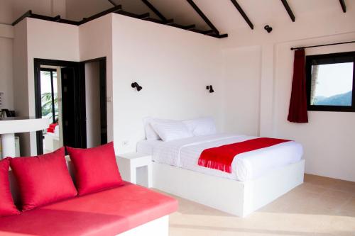 涛岛卡罗别墅的卧室配有白色的床和红色沙发