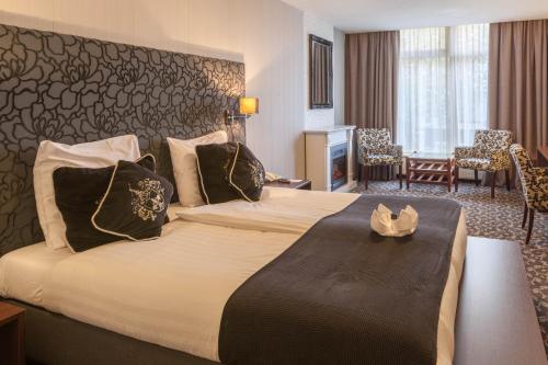 厄伊特霍伦Amsterdam Hotel Uithoorn的酒店客房设有一张大床和一间客厅。