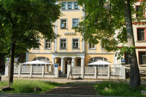 魏玛阿尔特维马尔酒店的前面有两把白色遮阳伞的建筑