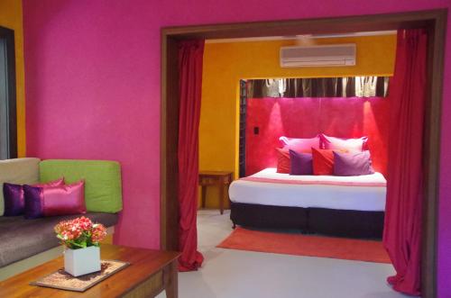 道格拉斯港粉红火烈鸟度假酒店的带镜子和沙发的床的房间