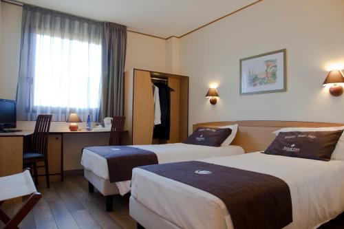 蒙卡列里南都灵郁金香酒店的酒店客房配有两张床和一张书桌