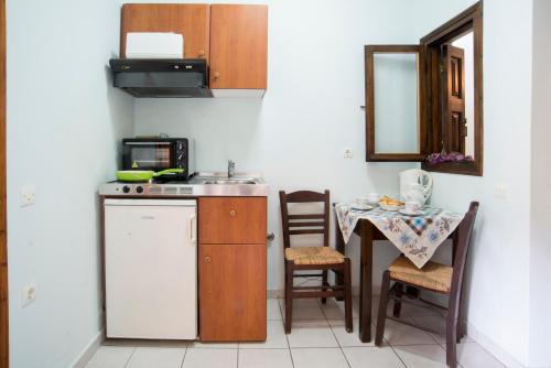 拉卡Studios Leandros的厨房配有水槽和桌椅