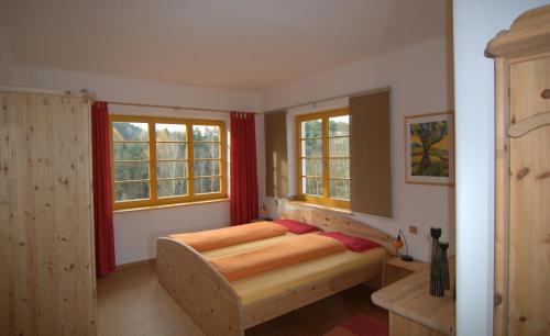 StruppenÖkopension Villa Weissig的一间卧室设有一张床和两个窗户。