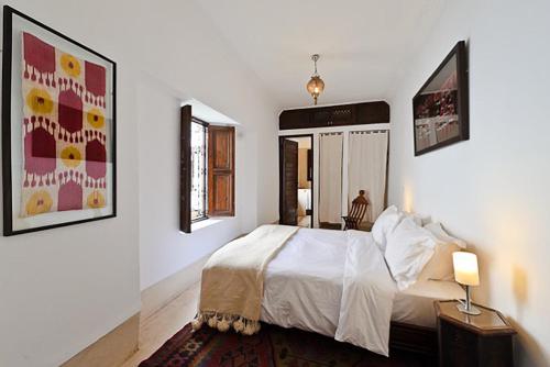 马拉喀什Riad Porte Royale的卧室配有白色的床和两面镜子