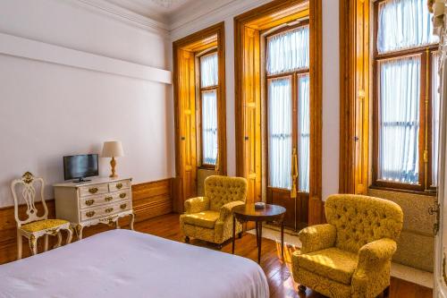 波尔图Porto Alegria Garden的一间卧室配有一张床、两把椅子和一张桌子