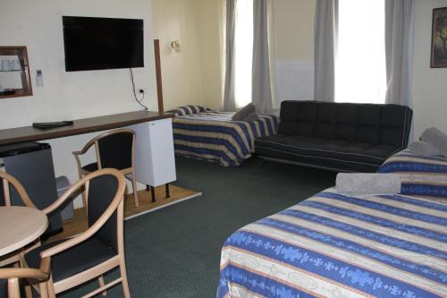 古尔本阿尔卑斯文物汽车旅馆的酒店客房配有床、沙发和电视。