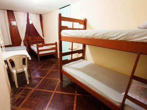 贝伦Hostel Amazonia的客房设有两张双层床和一张桌子及椅子。