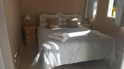 拉安戈斯图拉镇Magda的卧室配有白色床和毛巾