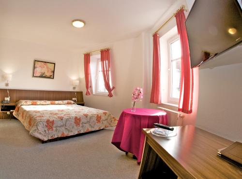 齐陶Hotel Weberhof的一间卧室配有一张床和一张鲜花桌子