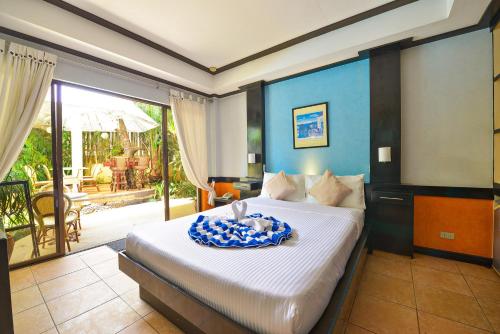 长滩岛Villa Sunset Boracay的一间带大床的卧室和一个阳台