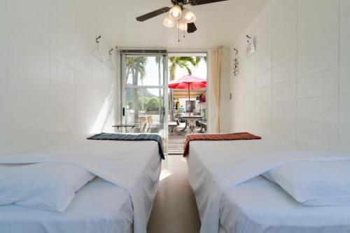 座间味村阿嘉岛哈那木罗酒店的庭院景客房 - 带两张床