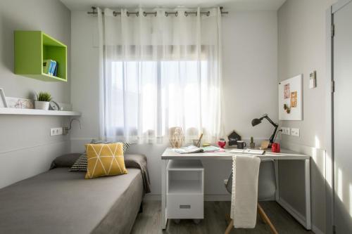 巴塞罗那巴塞罗那大学对角线旅馆的客房设有沙发、书桌和窗户。