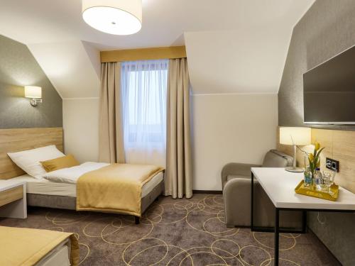 ZliniceHotel Antek的酒店客房,配有床和沙发
