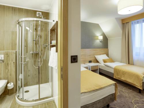 ZliniceHotel Antek的酒店客房设有淋浴和一间卧室。