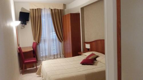 阿斯蒂Hotel Cavour的卧室配有床、椅子和窗户。