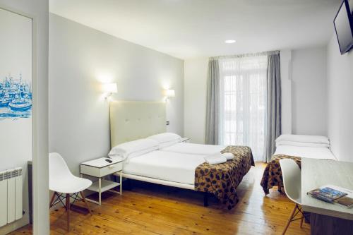 毕尔巴鄂古里亚休闲旅馆的酒店客房配有两张床和一张书桌
