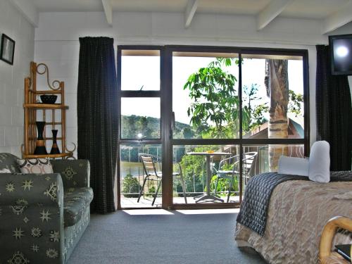 派西亚Waterfalls Estate - Falls Motel & Waterfront Campground的一间卧室设有一张床,享有阳台的景色