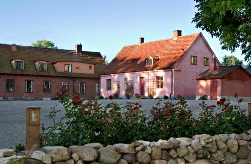 布勒萨普布罗萨捷斯提芙丽酒店暨SPA的粉红色的房子,前面有石墙