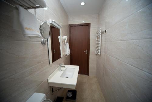 第比利斯伊比利亚迪杜贝酒店的一间带水槽、镜子和卫生间的浴室