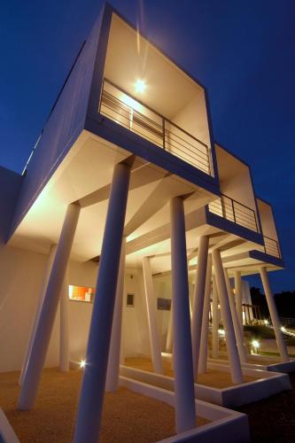 宫古岛RENN私人度假酒店的柱子上的房子,晚上有灯