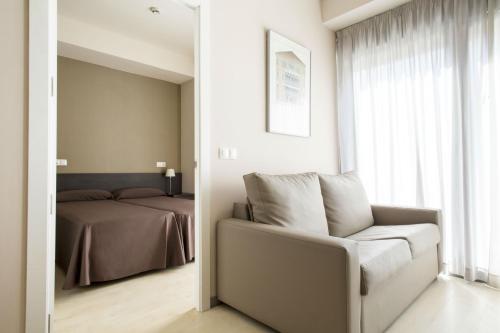 瓦伦西亚达米亚博内特大学旅舍的一间卧室配有一张床、一把椅子和镜子