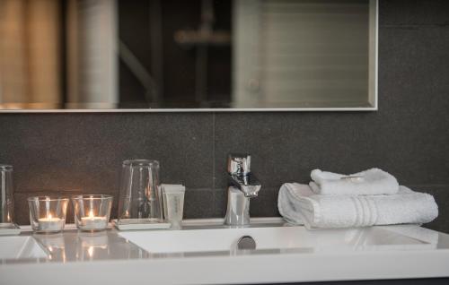 莫尔希普康帕斯酒店的浴室水槽配有毛巾和玻璃杯
