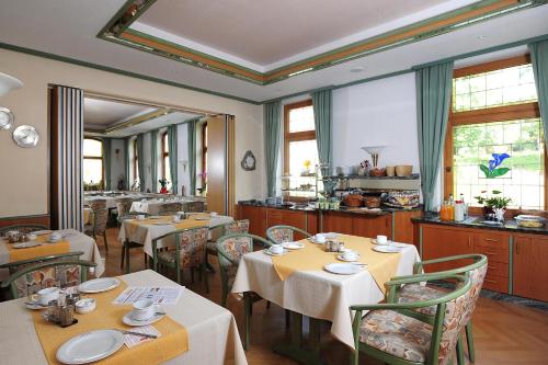 普劳恩Landhotel Plauen - Gasthof Zwoschwitz的用餐室设有桌椅和窗户。