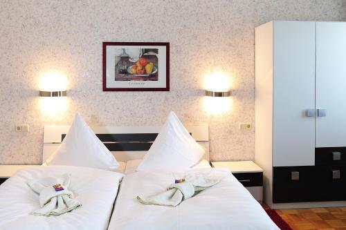 普劳恩Landhotel Plauen - Gasthof Zwoschwitz的一间卧室配有两张白色床和毛巾