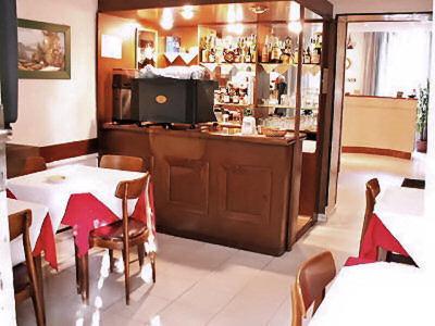 米兰拉力酒店的餐厅设有酒吧,配有桌椅