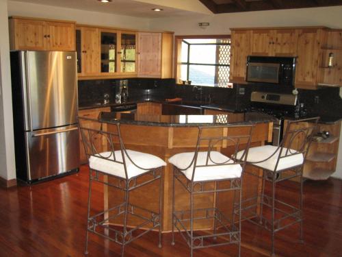 三河城阿尔塔山峰美景度假屋的厨房配有椅子和冰箱。
